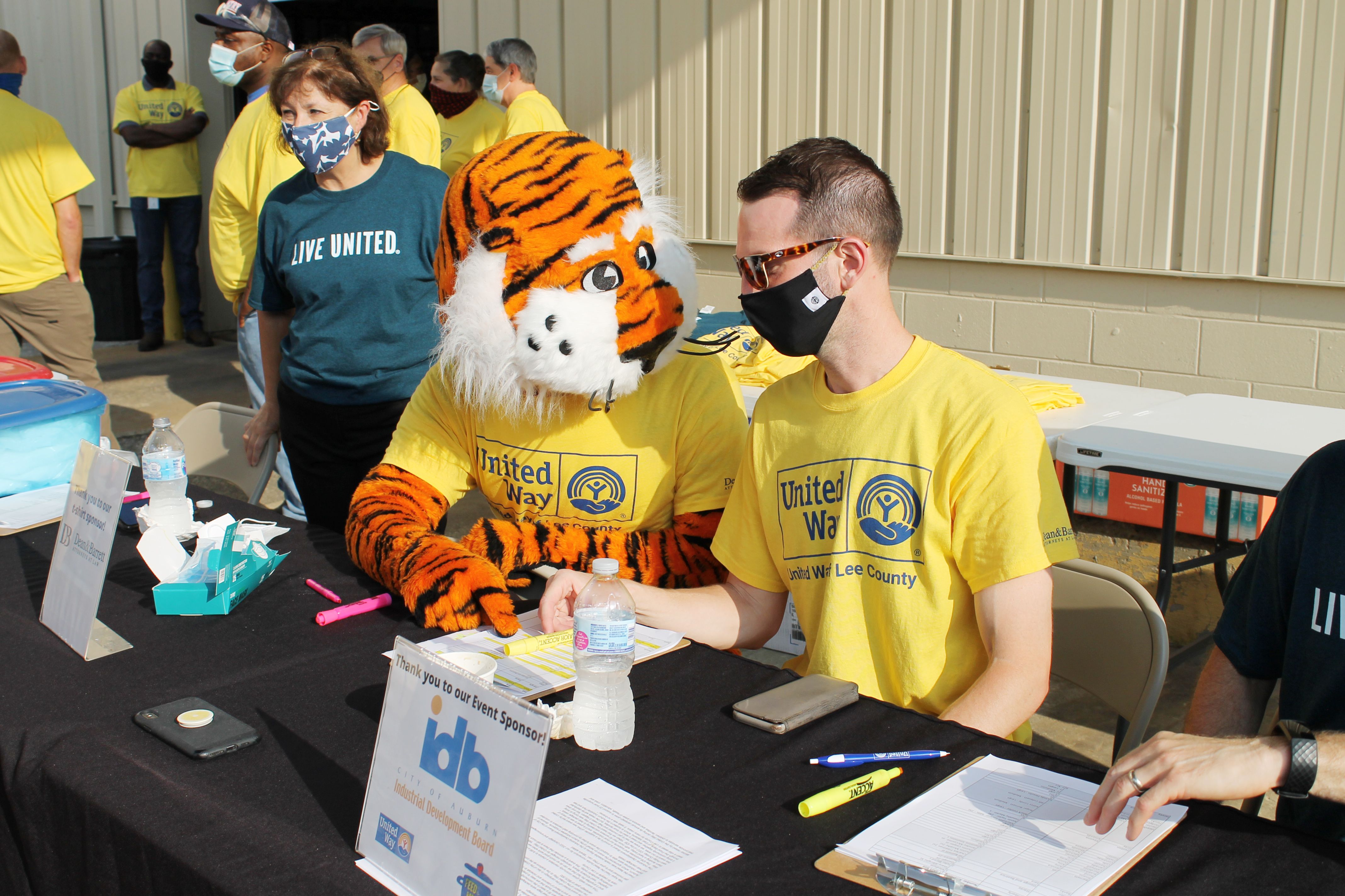 Aubie and a volunteer working the check in table