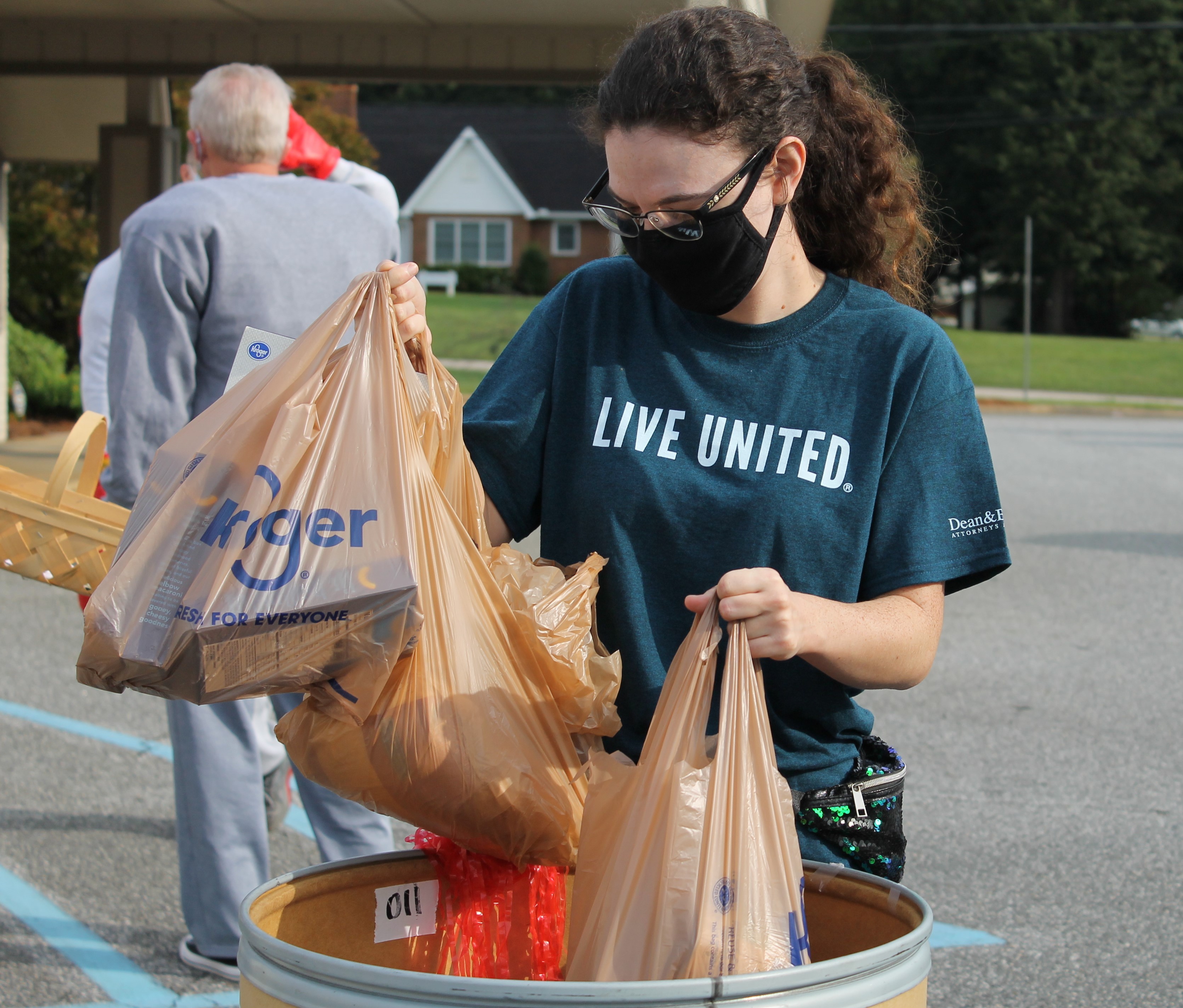 United Way staff member placing canned good donations into the collection bin