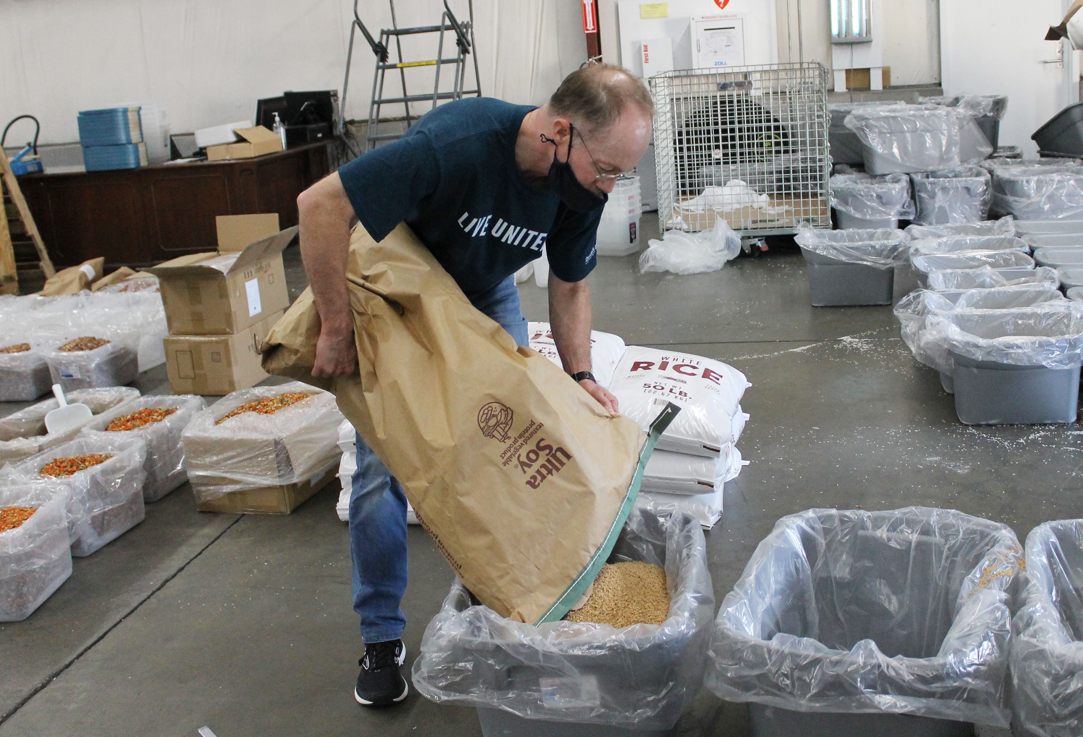 Volunteer emptying food into a container