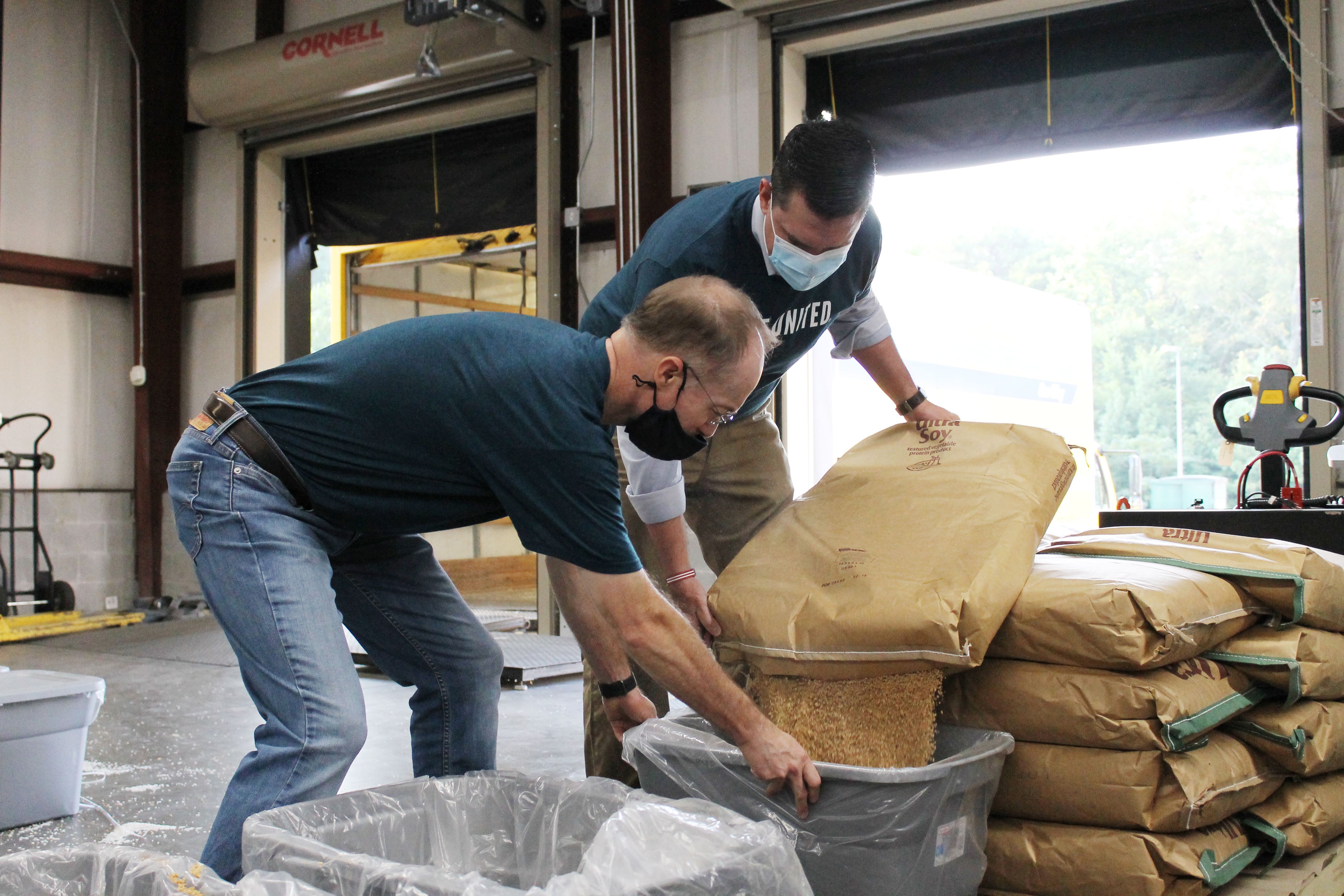 Volunteers lifting food