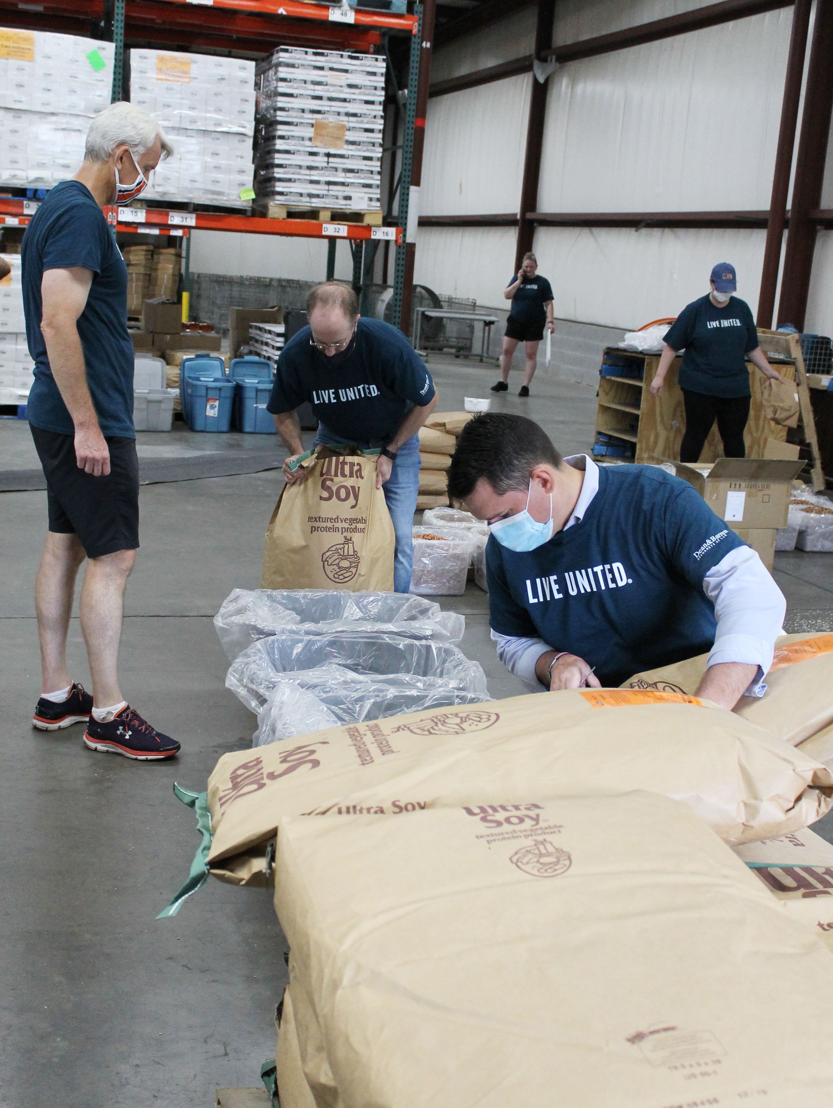 Volunteer sealing a box of completed meals